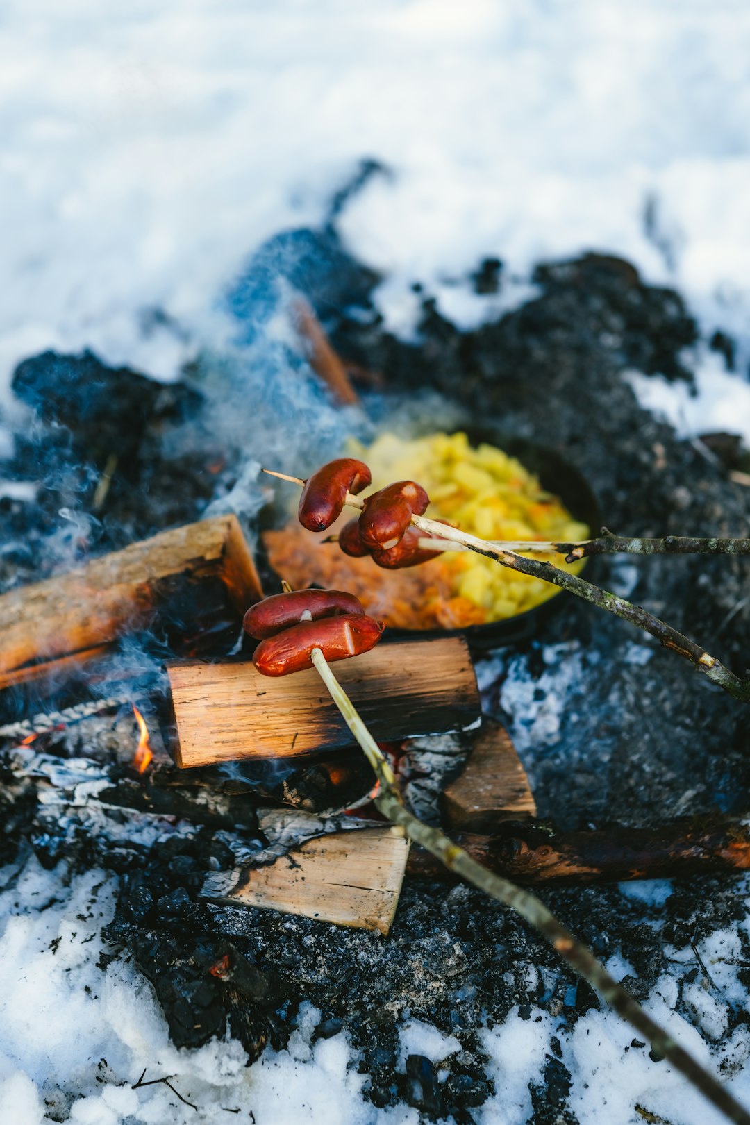 sausages-cooking-over-a-campfire-in-the-snow-sxylqbui5am